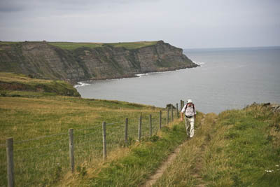 A walker on a coastal path near Robin Hood's Bay, North Yorkshire