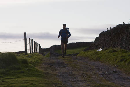 Jez Bragg approaches the last checkpoint at Yarnbury as dusk approaches