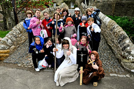 Pupils of Ceres Primary School gather at the villages Bishops Bridge to receive a pilgrim as she travels along the ancient route to St Andrews. Photo: Marc Marnie