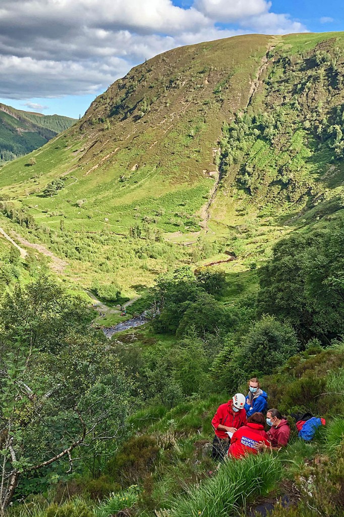 Team members, wearing protective equipment, assess the casualty. Photo: Aberdyfi SRT Team members, wearing protective equipment, assess the casualty. Photo: Aberdyfi SRT