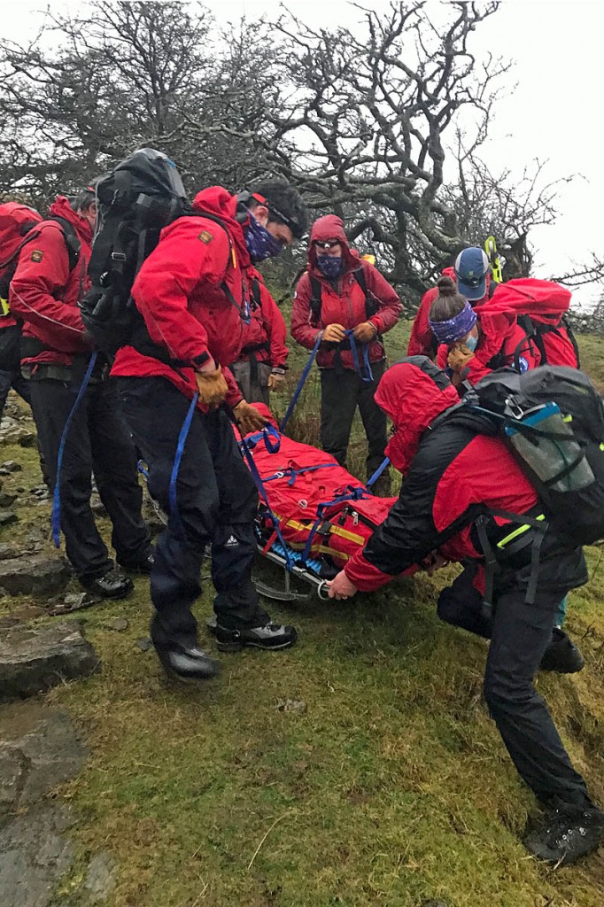 Rescuers manoeuvre the stretcher down rock steps . Photo: Aberdyfi SRT