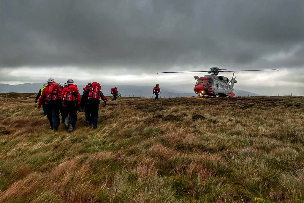 Team members stretcher the injured man to the Coastguard helicopter. Photo: Aberdyfi SRT Team members stretcher the injured man to the Coastguard helicopter. Photo: Aberdyfi SRT