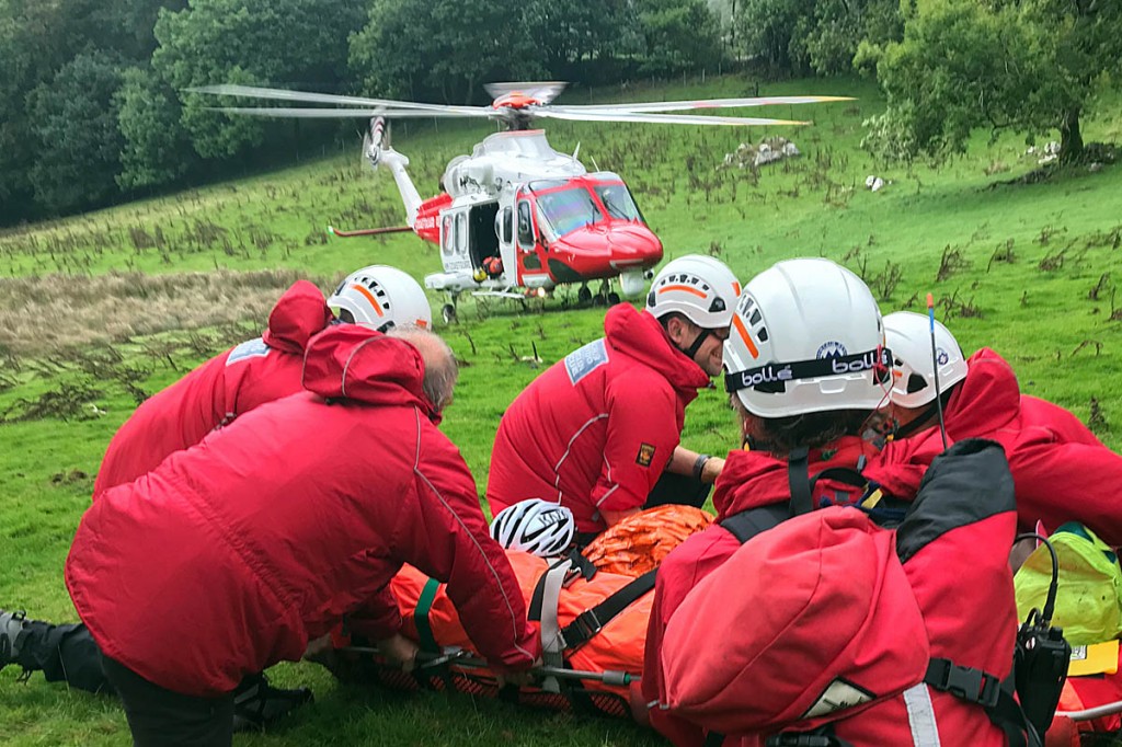Rescuers with the injured cyclist and the Coastguard helicopter. Photo: Aberdyfi SRT