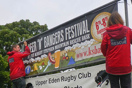 Mountain rescue team members Steve Howarth and Sarah Harvey install a festival banner on the road into Kirkby Stephen Mountain rescue team members Steve Howarth and Sarah Harvey install a festival banner on the road into Kirkby Stephen