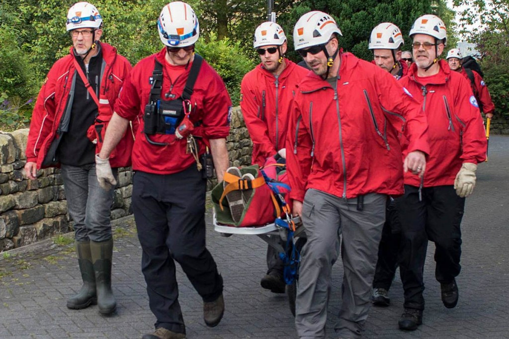 Rescue team members stretcher the injured climber to an ambulance. Photo: Calder Valley SRT Rescue team members stretcher the injured climber to an ambulance. Photo: Calder Valley SRT