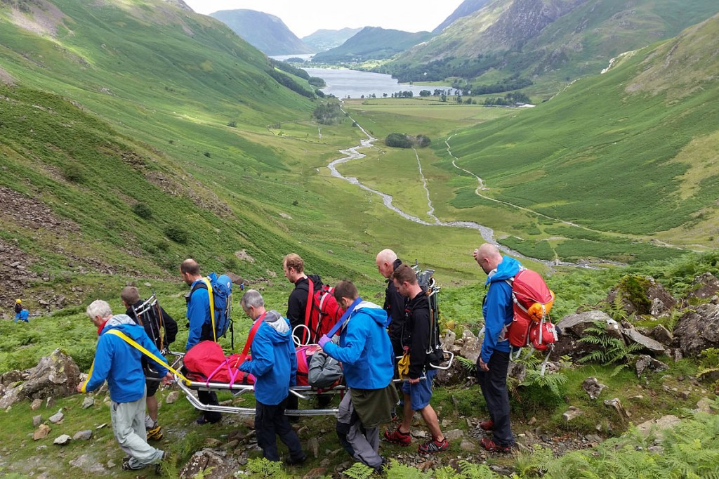 Rescuers stretcher the injured walker from the fell. Photo: Cockermouth MRT