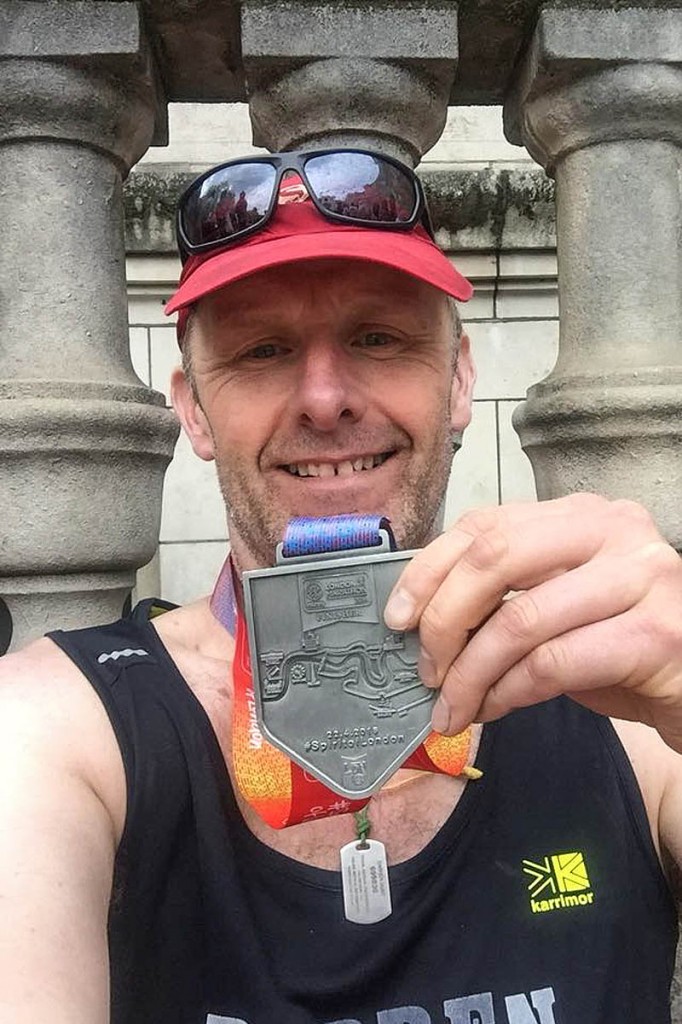 Darren Hunt shows his finisher's medal at the London Marathon