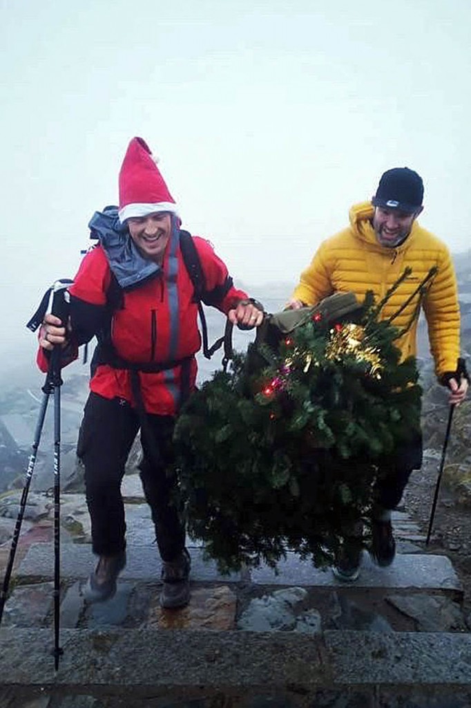The two men carry the tree to the final summit