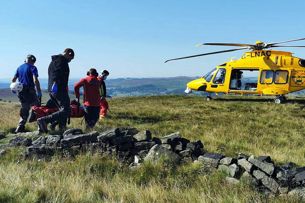 Team members strecher a casualty to an air ambulance. Photo: Edale MRT Team members strecher a casualty to an air ambulance. Photo: Edale MRT