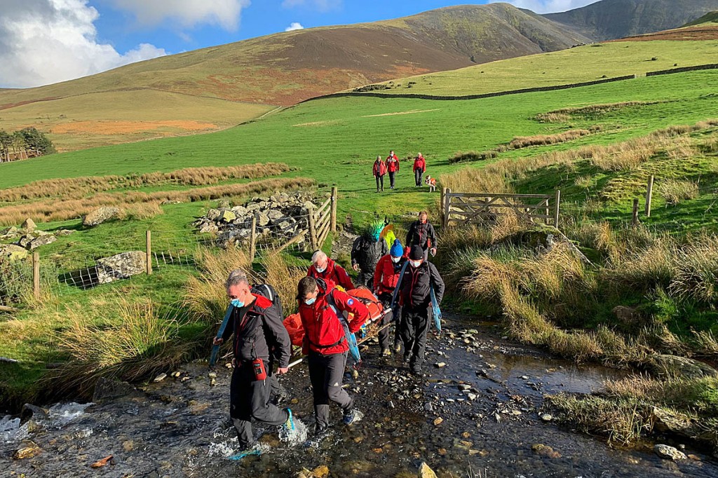 Team members stretcher the walker from the fell. Photo: Keswick MRT Team members stretcher the walker from the fell. Photo: Keswick MRT