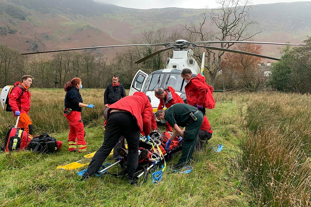Rescuers with the mountain biker and the air ambulance. Photo: Keswick MRT Rescuers with the mountain biker and the air ambulance. Photo: Keswick MRT