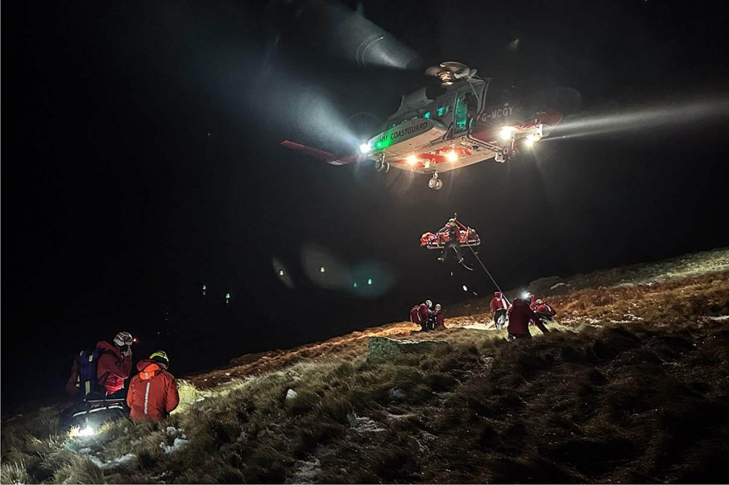The Coastguard helicopter crew winch the injured man into their helicopter. Photo: Keswick MRT