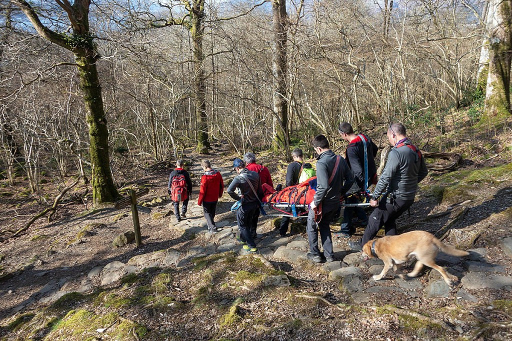 Rescuers stretcher the injured walker from the fell. Photo: Keswick MRT
