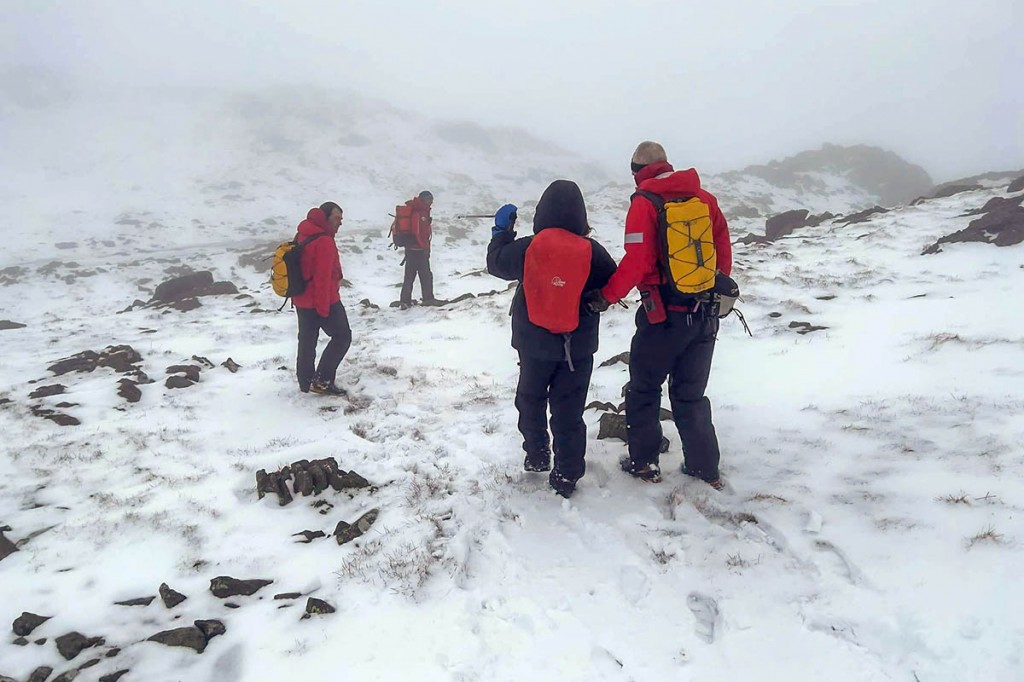 Rescuers escort one of the walkers from the fell. Photo: Keswick MRT