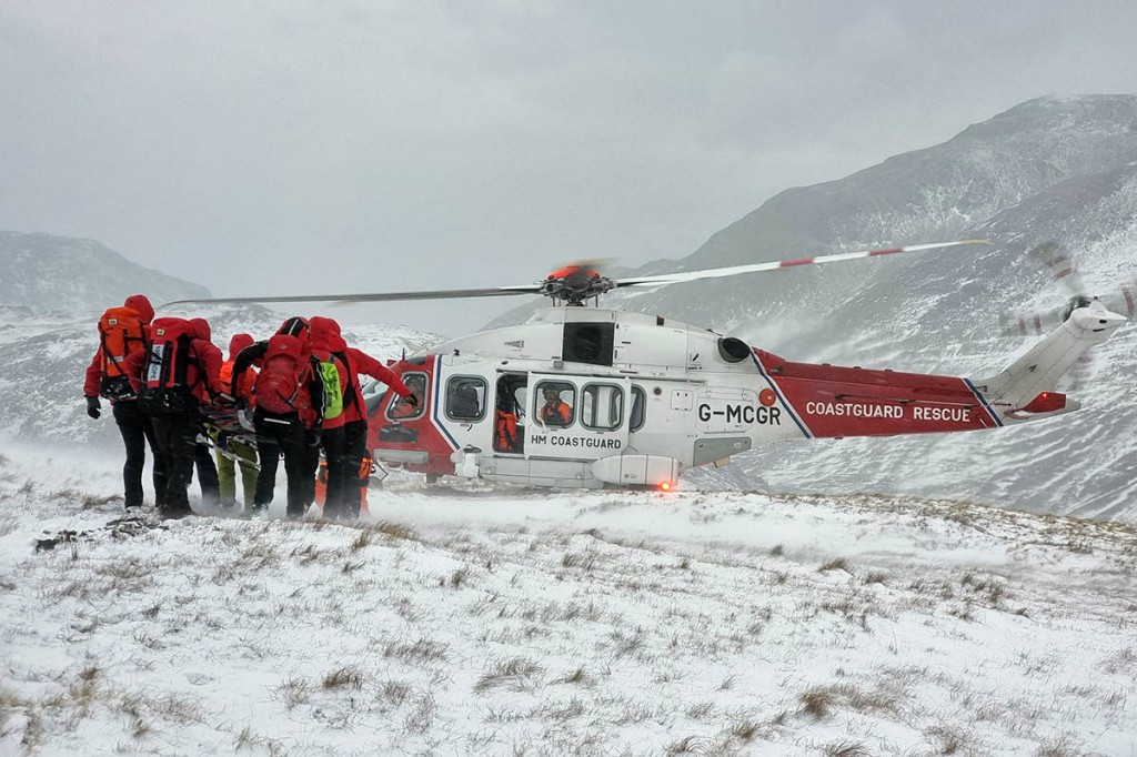 Rescuers carry the injured man to the Coastguard helicopter. Photo: Keswick MRT