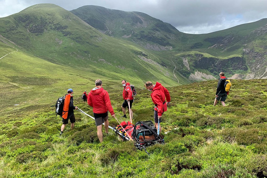 The injured walker is sledged from Outerside by team members. Photo: Keswick MRT
