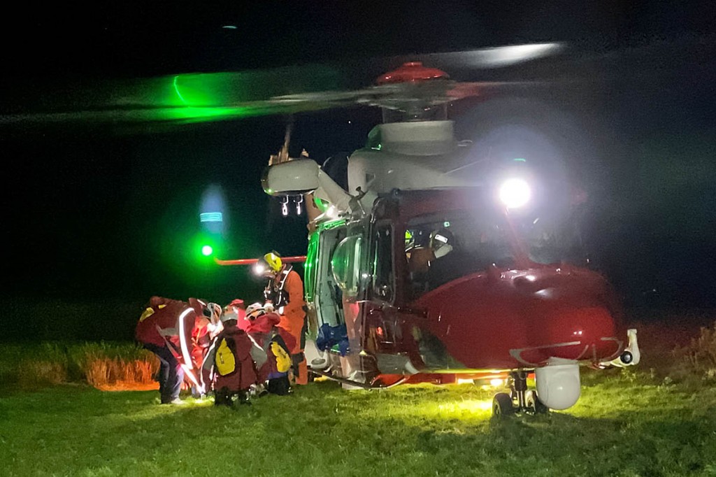Rescuers with the Coastguard helicopter and the injured man. Photo: Keswick MRT