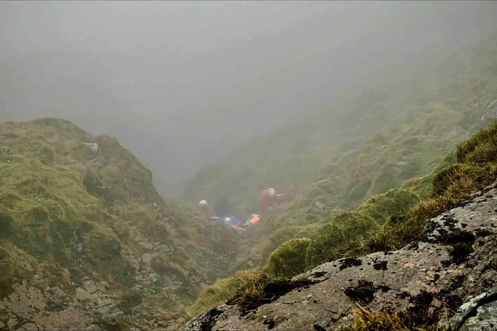 Rescuers with the fallen walker in the gully. Photo: Keswick MRT Rescuers with the fallen walker in the gully. Photo: Keswick MRT