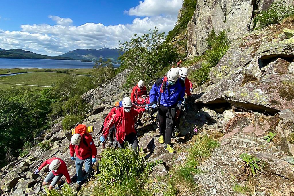 Rescuers stretcher the climber from the crag. Photo: Keswick MRT Rescuers stretcher the climber from the crag. Photo: Keswick MRT
