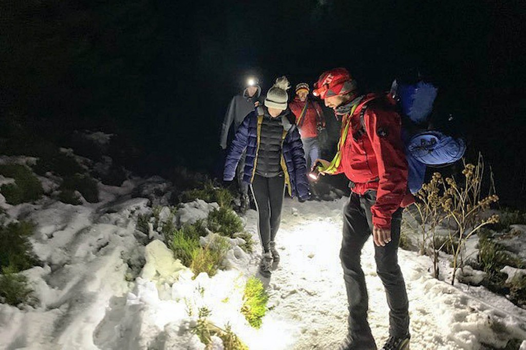 Rescuers aid the two forest walkers to safety. Photo: Keswick MRT Rescuers aid the two forest walkers to safety. Photo: Keswick MRT