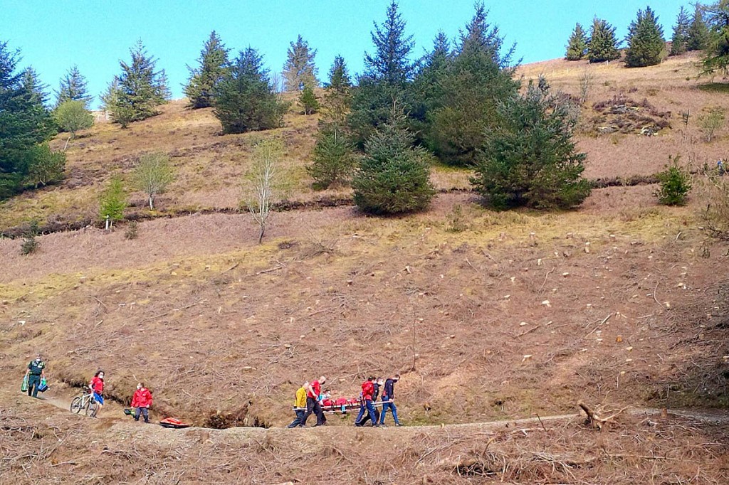 Rescue team members stretcher the injured mountain biker from the scene. Photo: Keswick MRT Rescue team members stretcher the injured mountain biker from the scene. Photo: Keswick MRT