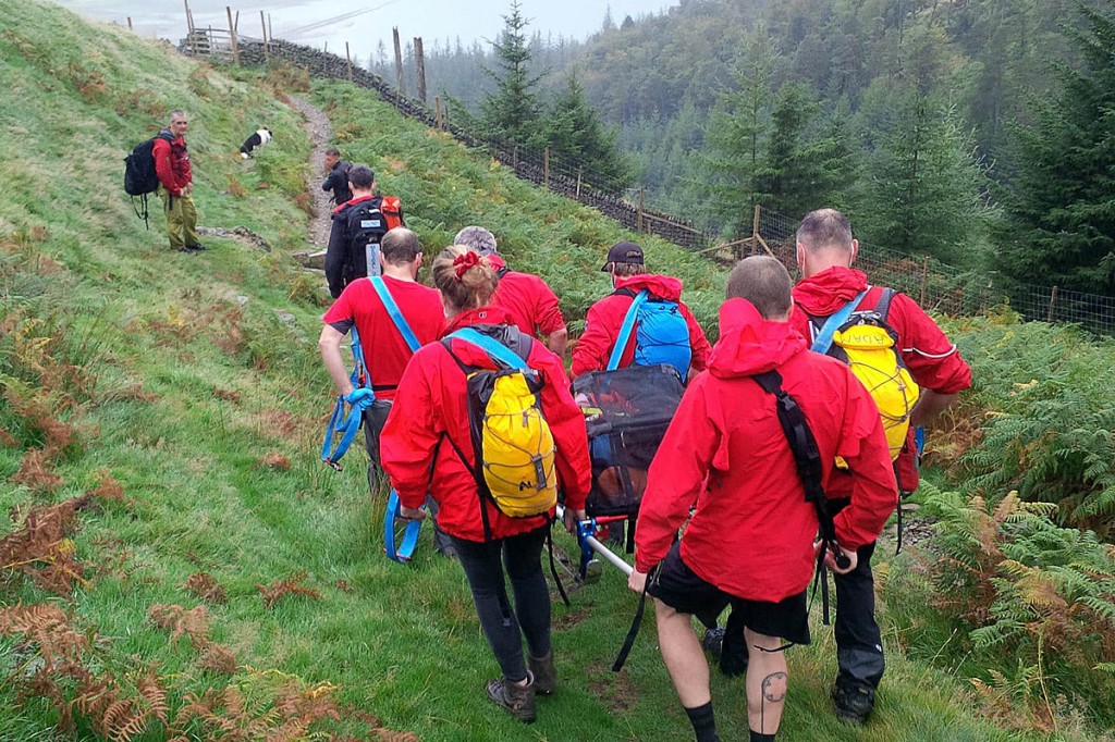 Team members stretcher the injured walker from the fell. Photo: Keswick MRT