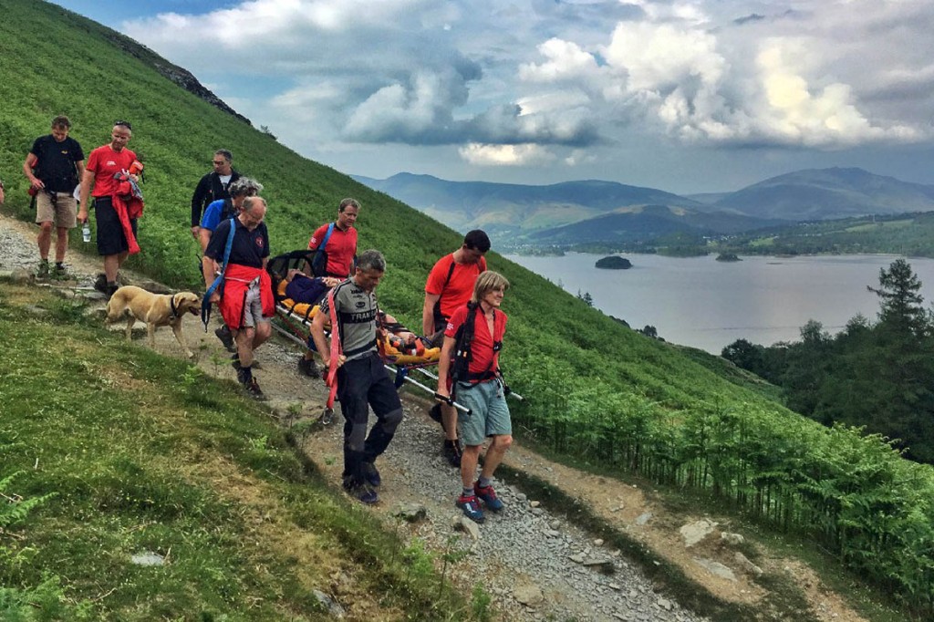 Rescuers stretcher the injured walker from the fell. Photo: Keswick MRT