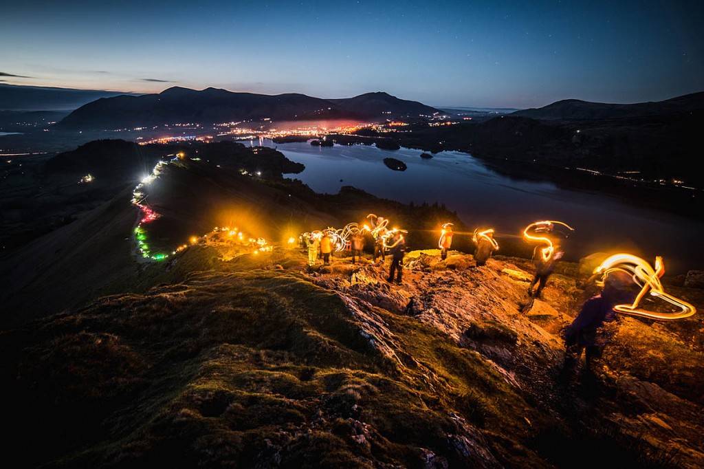 Walkers light up Cat Bells, with Derwent Water and Keswick in the distance. Photo: Harry Baker Photography