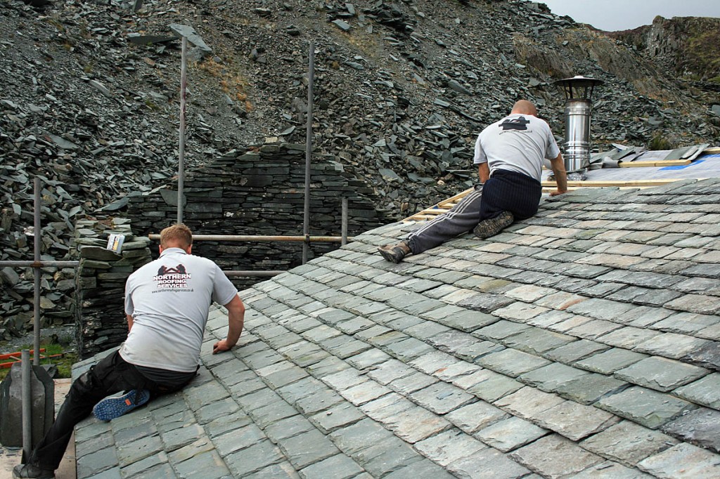 Workers reslate the roof. Photo: MBA