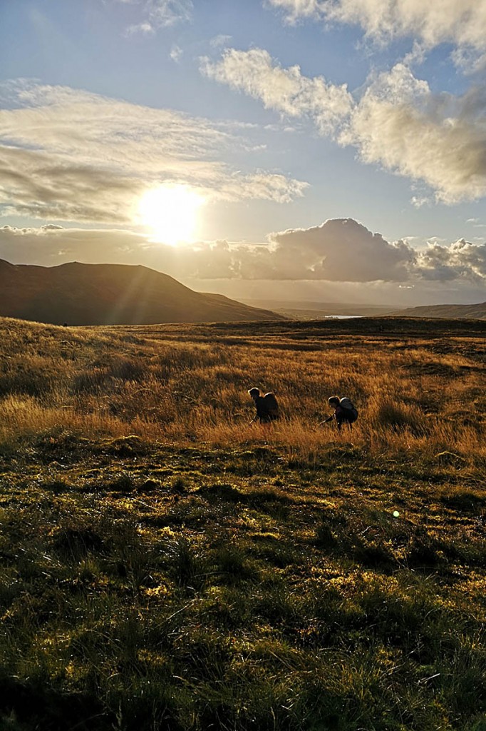 Two competitors make their way across the boggy terrain Two competitors make their way across the boggy terrain
