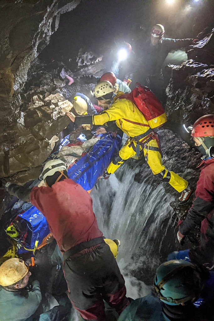 Rescuers stretcher the caver through the system. Photo: SMWCRT Rescuers stretcher the caver through the system. Photo: SMWCRT