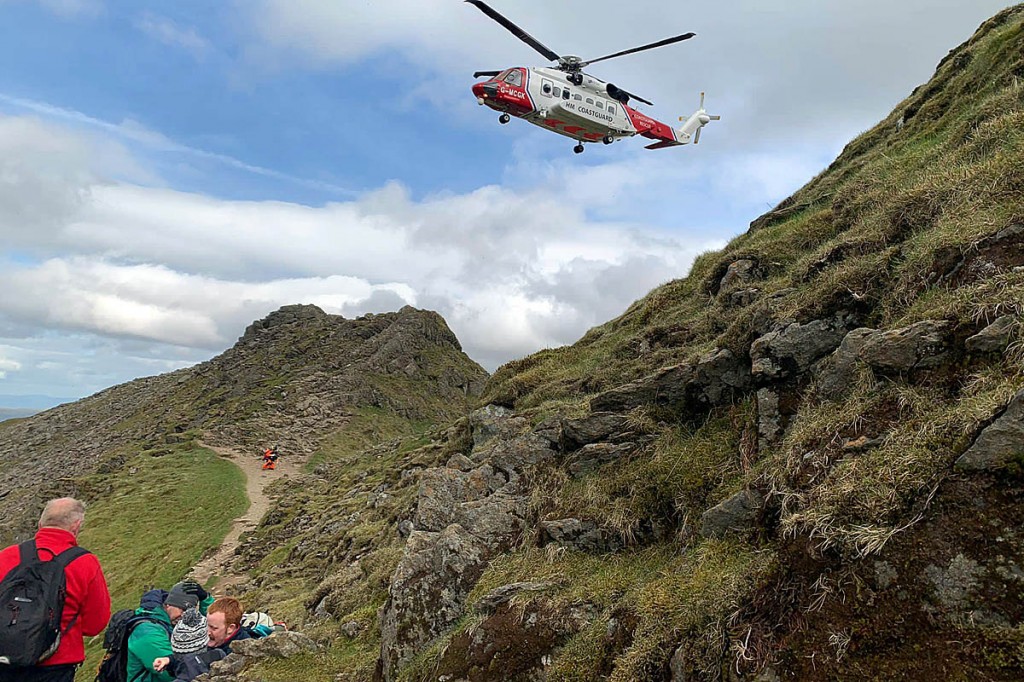 The Coastguard helicopter and rescuers at the scene on Striding Edge. Photo: Patterdale MRT