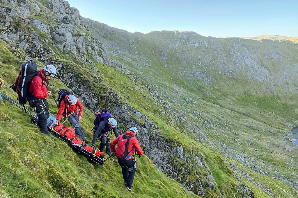 Team members lower the man from the ridge. Photo: Patterdale MRT