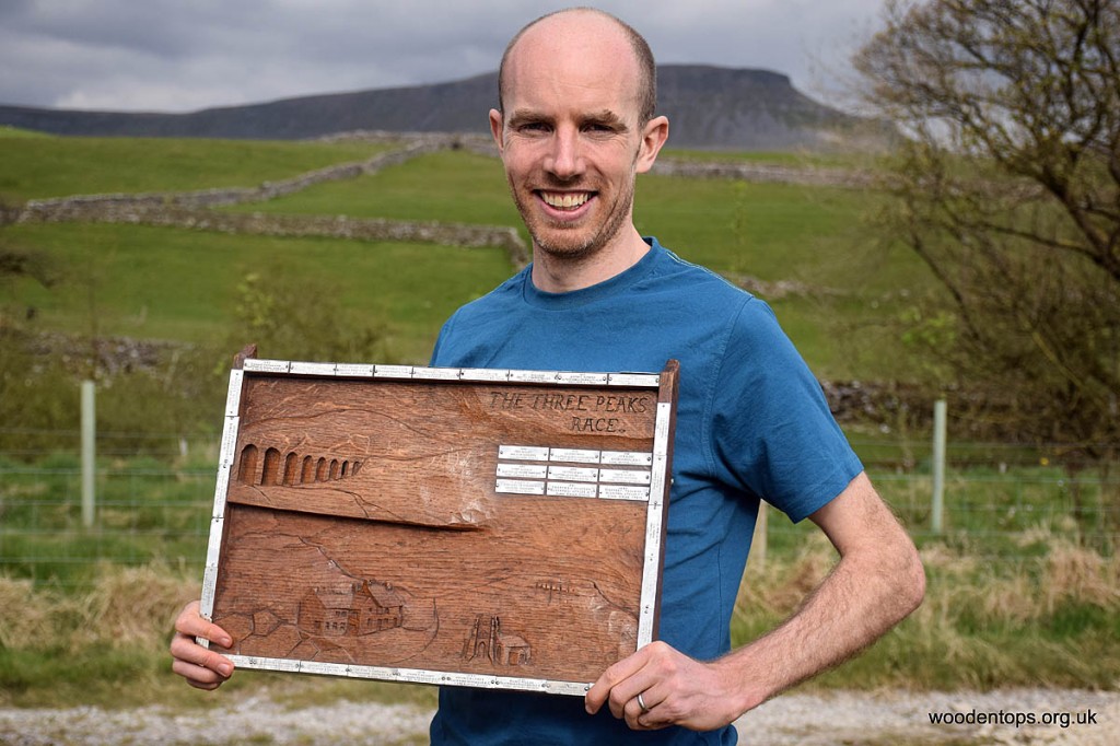 Murray Strain holds the winner's plaque, with Pen-y-ghent in the distance