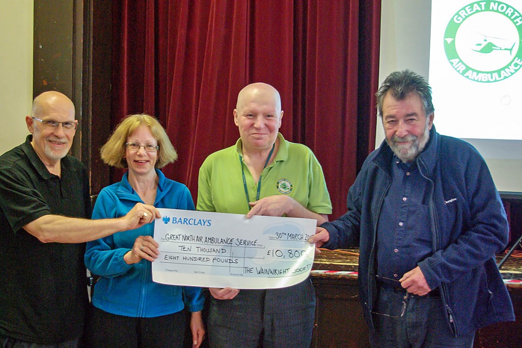 Bruce Evans, second from right, of the Great North Air Ambulance, receives a cheque from Nick Holmes and Caroline Nichol of the Wainwright Society, and its chairman Eric Robson, right. Photo: David Johnson
