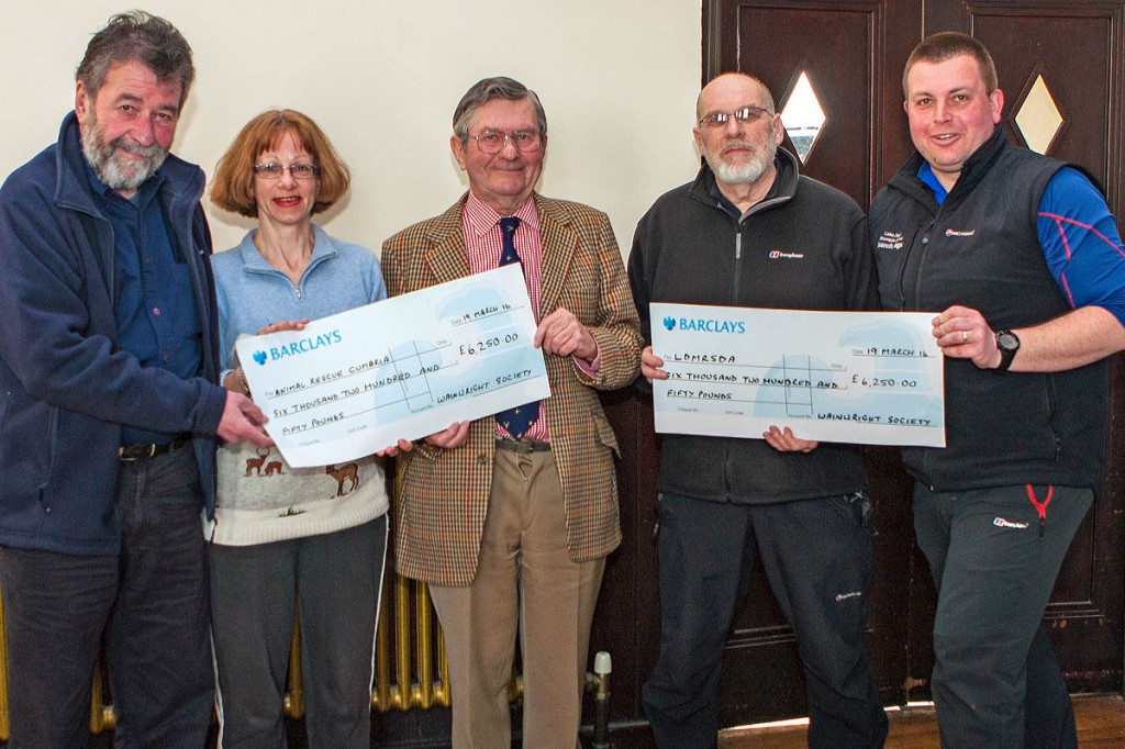 Wainwright Society chairman Eric Robson, left, hands out cheques to, from left: Caroline Nichol and John Estensen ofAnimal Rescue Cumbria; Nick Holmes and John Leadbetter of Lake District Mountain Rescue Search Dogs. Photo: Andrew Stainthorpe