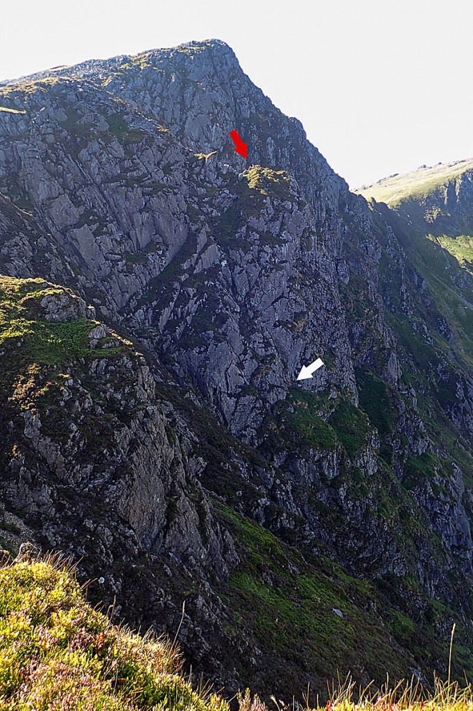 The rescue scene, with the position of the cragfast pair indicated by the white arrow and the site of the rescuers by the red arrow. Photo: Aberdyfi SRT