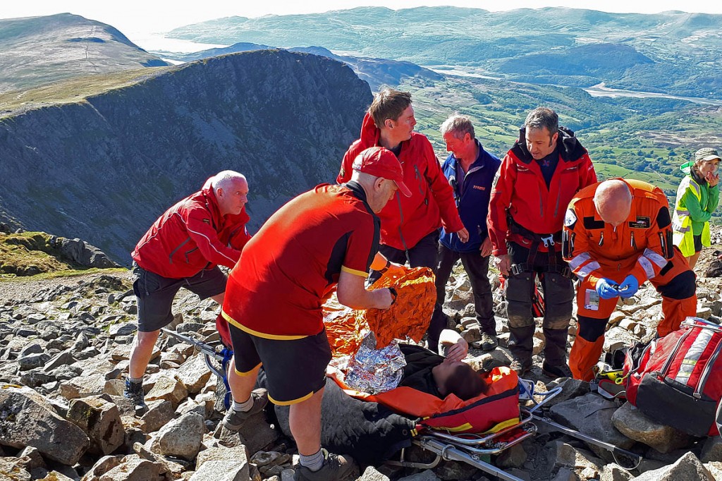 Rescue team volunteers, national park rangers, helicopter paramedics and race marshals tend to the injured woman near the summit of Cadair Idris. Photo: Aberdyfi SRT