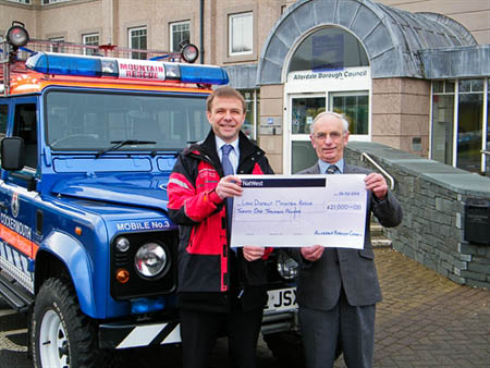 Steve Brailey, left, on behalf of the Lake District Search and Mountain Rescue Association, receives the £21,000 cheque from Councillor Tim Heslop, leader of Allerdale Borough Council 