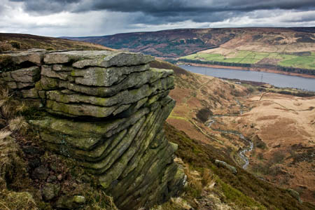 A gritstone outcrop above Torside Clough on Bleaklow, with Torside Reservoir in the distance