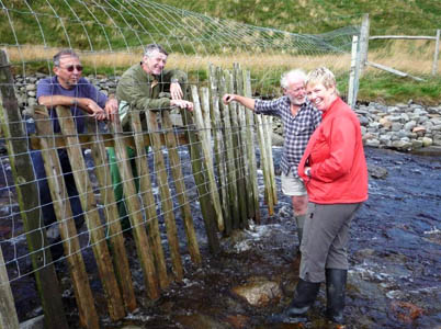 Volunteers with the new watergate installed to protect new woodland from grazing animals at High Borrowdale