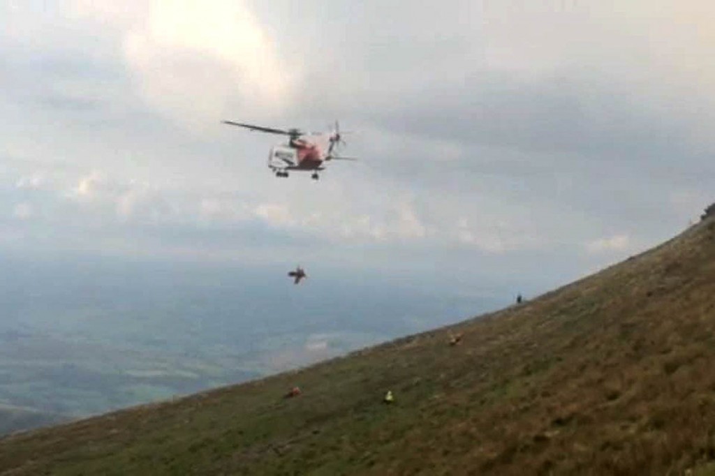 The injured man is winched into the helicopter from the slopes of Corn Du. Photo: Brecon MRT The injured man is winched into the helicopter from the slopes of Corn Du. Photo: Brecon MRT