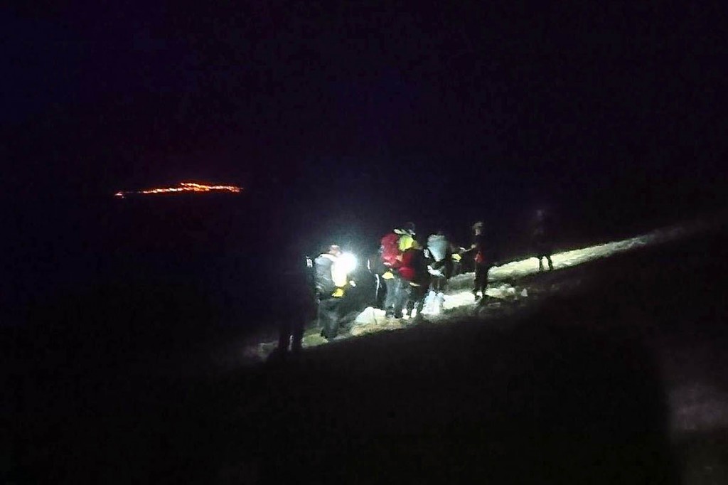 The rescue party descends the mountain, with the lights of Aviemore in the distance. Photo: Cairngorm MRT