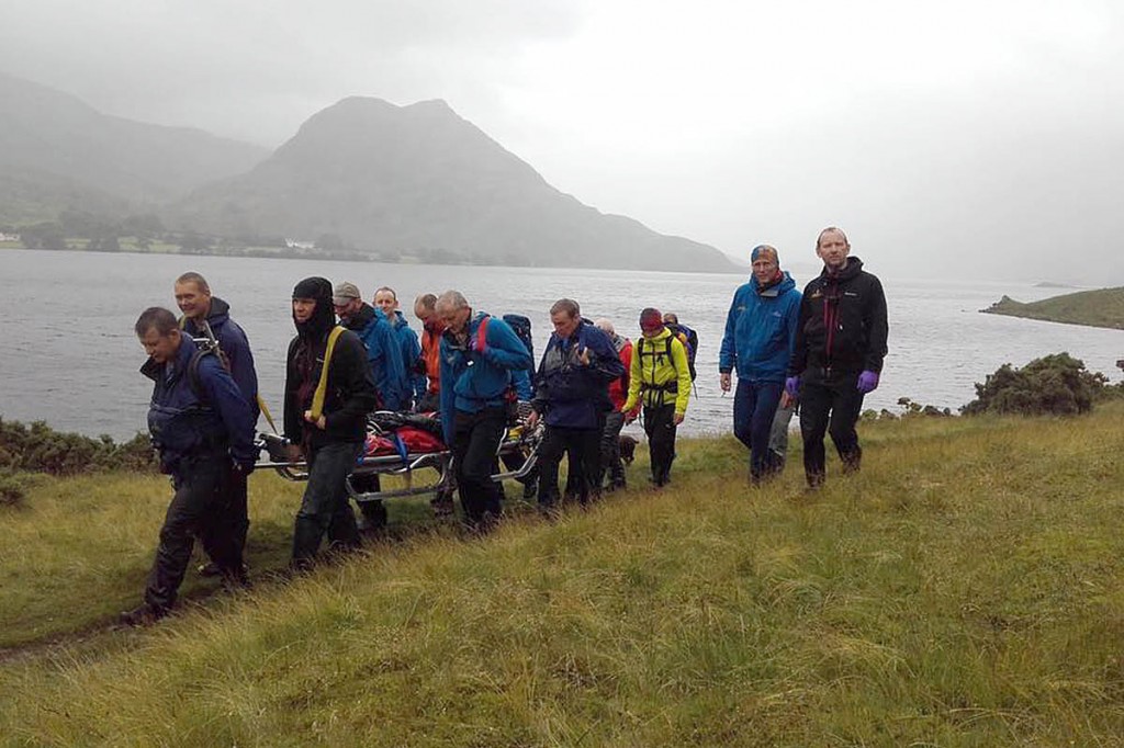 Team members stretcher the injured runner from the lake shore. Photo: Cockermouth MRT Team members stretcher the injured runner from the lake shore. Photo: Cockermouth MRT