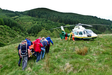 The rescue team stretchers the walker to a waiting air ambulance. Photo: Cockermouth MRT The rescue team stretchers the walker to a waiting air ambulance. Photo: Cockermouth MRT