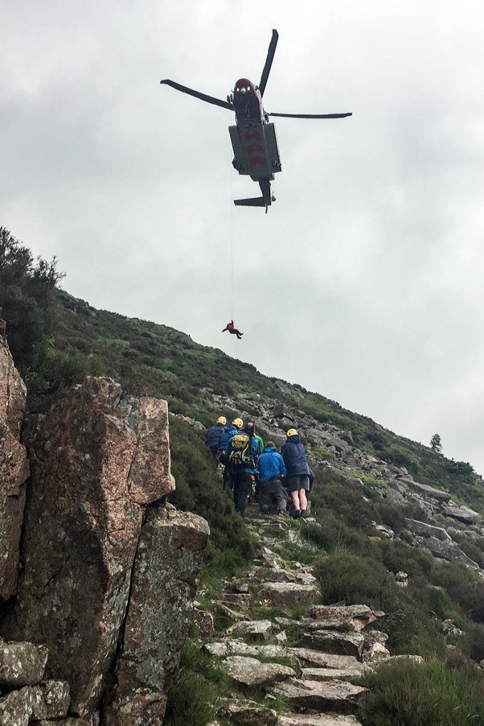 Cockermouth team members at the scene as the Coastguard helicopter prepares to winch the injured man. Photo: Cockermouth MRT