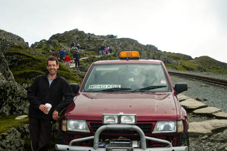 Craig Williams stands beside the maroon Frontera on Snowdon