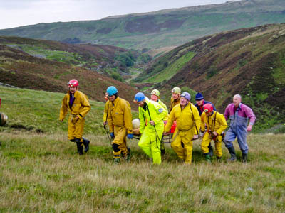 Members of the CRO carry a casualty across moorland