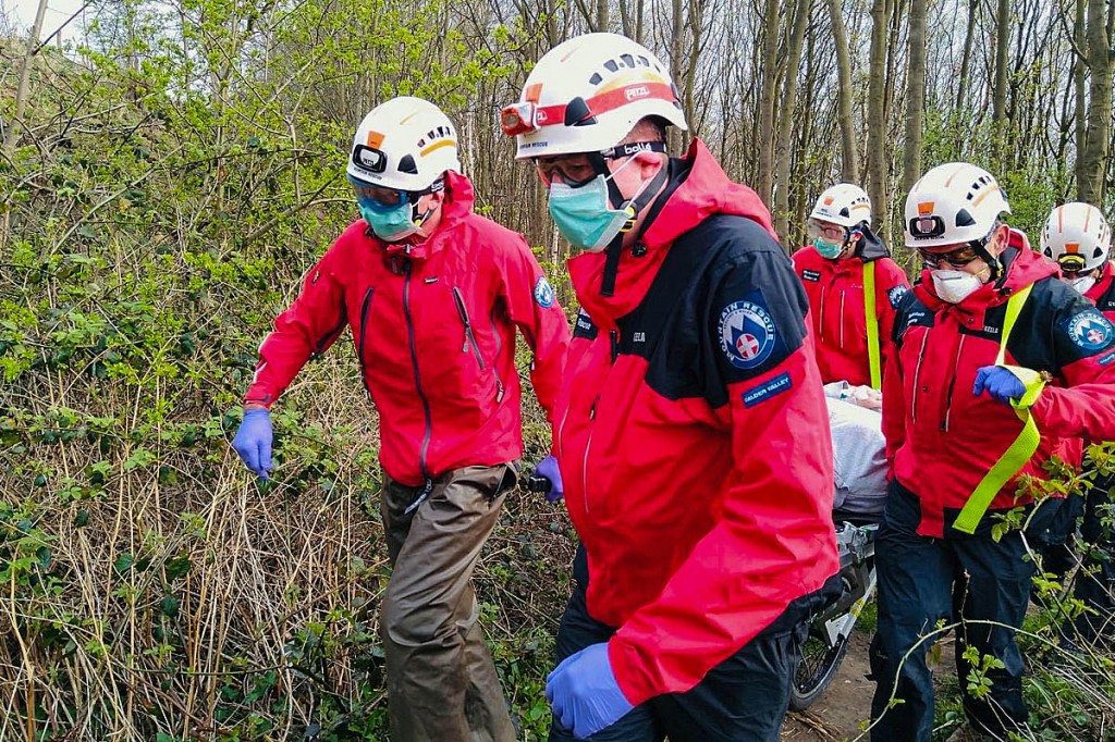 Rescuers wearing protective equipment stretcher the injured walker from the woods. Photo: CVSRT Rescuers wearing protective equipment stretcher the injured walker from the woods. Photo: CVSRT