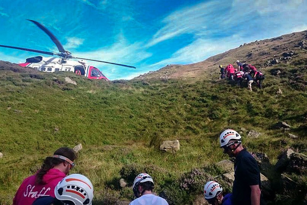 Rescuers stretchered the injured walkers up a steep slope to the helicopter. Photo: Edale MRT